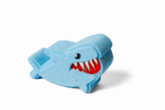 Blue shark-shaped bath bomb or bath fizzer with a red mouth from side.